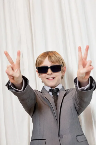 戴着太阳镜的小男孩打着和平的手势 — 图库照片