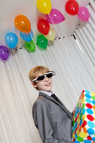 Glücklicher Kleiner Junge Mit Sonnenbrille Hält Geschenk Auf Party — Stockfoto