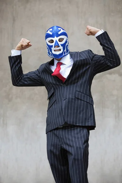 若いですビジネスマン曲げ筋肉でレスリングマスク上のグレーの背景 — ストック写真