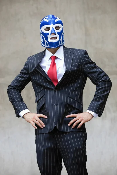 身穿条纹西装 戴着灰色背景摔跤面具的年轻商人 — 图库照片