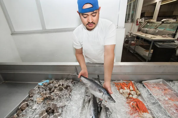 Giovane Pescivendolo Che Sorregge Sgombro Mezzo Pesce Misto Sul Ghiaccio — Foto Stock