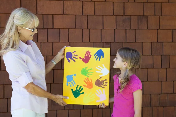 Бабуся Онука Показує Різнокольорові Відбитки Кількох Рук Цегляній Стіні — стокове фото