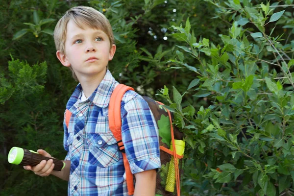 Pojke Med Ryggsäck Och Fackla Framför Växter — Stockfoto