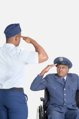 Erkek öğrenci, tekerlekli sandalyedeki kıdemli hava kuvvetlerini selamlıyor.