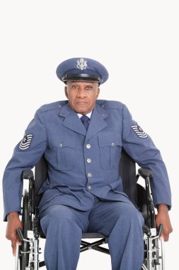 Gri arka planda tekerlekli sandalyede oturan yaşlı bir Amerikan Hava Kuvvetleri subayının portresi