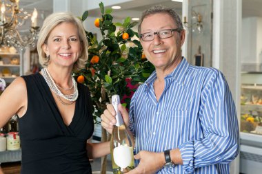 İçki şişesiyle gülümseyen olgun bir çiftin portresi.