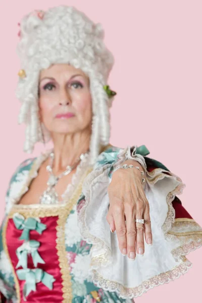 Портрет Старшей Королевы Протягивающей Руку Розовом Фоне — стоковое фото
