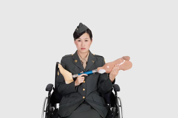 坐在轮椅上的美国女军官 灰色背景下的假肢 — 图库照片