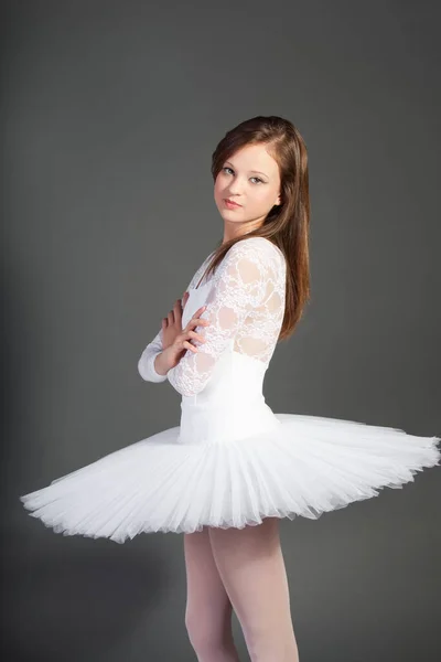 年轻女芭蕾舞者的画像 手臂交叉地站在灰色背景之上 — 图库照片