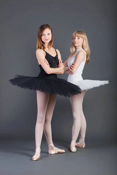 グレーを背景に腕を組んで立つ2人の若い女性バレエダンサーの肖像 — ストック写真