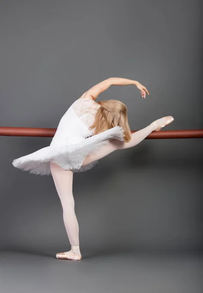 Young Female Ballet Dancer Stretching Ballet Bar Grey Background — Stock Photo, Image