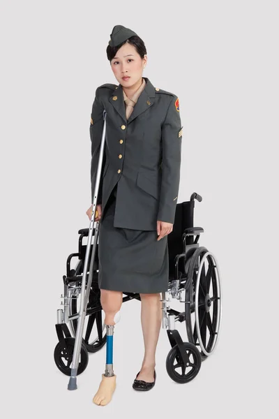 Perempuan Cacat Perwira Militer Dengan Kruk Berdiri Depan Kursi Roda — Stok Foto
