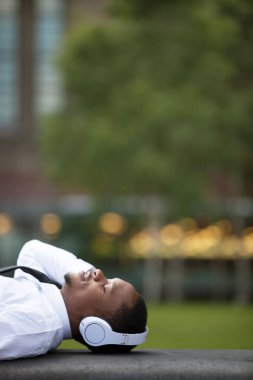 Dışarıda kulaklıkla müzik dinleyen Afrikalı bir adamın portresi.