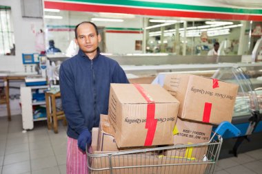 Alışveriş arabalı erkek işçinin portresi
