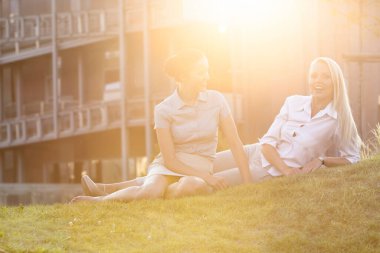 Genç iş kadınları ofis çimlerinde dinleniyor