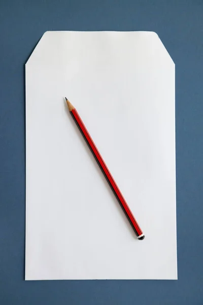 深蓝色表面上的铅笔和空白纸 — 图库照片