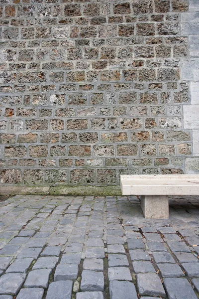 レンガの壁に対して空の石のベンチ — ストック写真