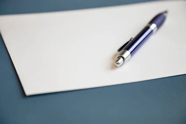 Koyu Mavi Arkaplan Üzerine Beyaz Kağıt Üzerine Metal Kalem — Stok fotoğraf