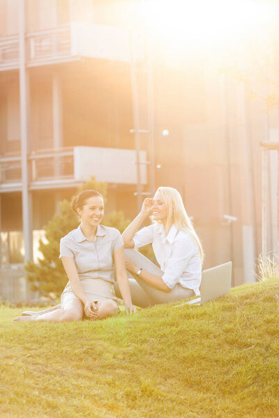 Young businesswomen gossiping in office lawn