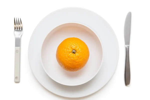 白い背景にフォークとナイフで皿のオレンジの高い角度ビュー — ストック写真