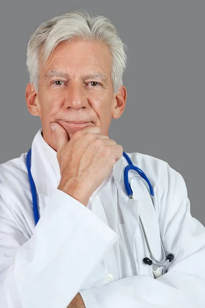 肖像画のシニア男性医師とともに手上のあご上灰色の背景 — ストック写真