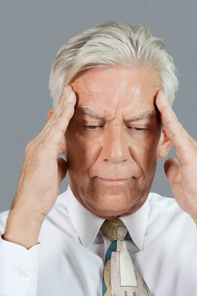 灰色の背景に頭痛を持つシニアビジネスマンのクローズアップ — ストック写真