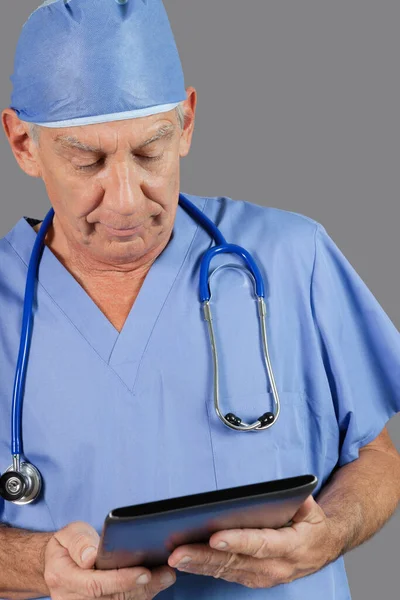 Starszy Chirurg Męski Korzystający Tabletu Szarym Tle — Zdjęcie stockowe