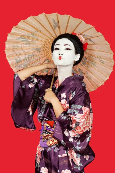 Kimonolu Japon Kadının Portresi Kırmızı Arka Planda Şemsiye Tutuyor — Stok fotoğraf