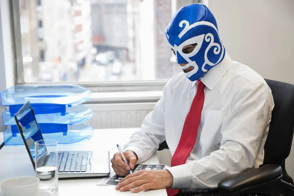 사무실에서 일하는 사업가가 사무실 책상에서 레슬링 마스크를 — 스톡 사진