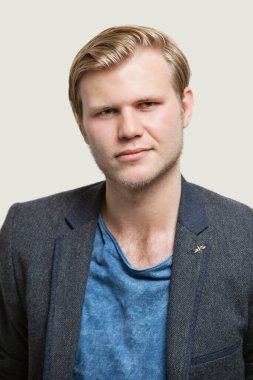 Gri arka planda kendinden emin genç iş adamının portresi