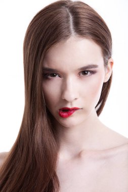 Dudağını beyaz arka planda ısıran güzel genç bir kadının portresi.