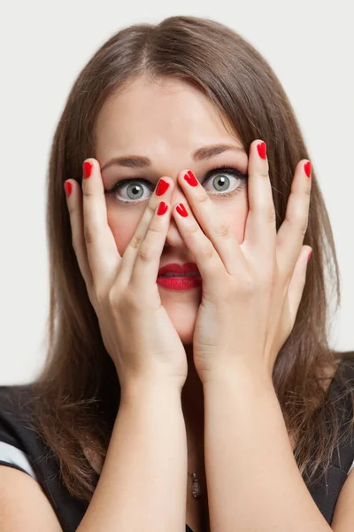灰色の目と灰色の背景に赤い塗装爪を持つ若い女性の肖像画 — ストック写真
