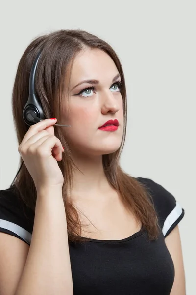 Νεαρή Γυναίκα Που Φοράει Ακουστικά Πάνω Από Γκρι Φόντο — Φωτογραφία Αρχείου