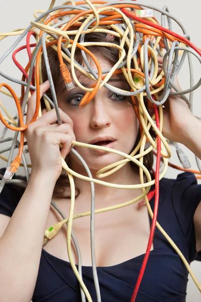 Shocked Young Woman Head Tangled Colorful Cables Gray Background — Stock Photo, Image
