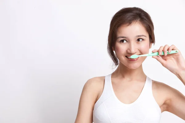 Beyaz Atletli Genç Asyalı Kadın Beyaz Arka Planda Dişlerini Fırçalıyor — Stok fotoğraf