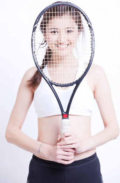 Портрет Улыбающейся Азиатки Держащей Теннисную Ракетку Перед Лицом Белом Фоне — стоковое фото