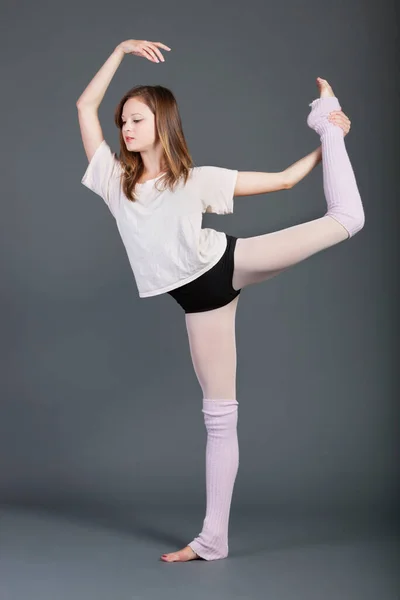 在灰色背景下表演芭蕾舞的年轻女子 — 图库照片