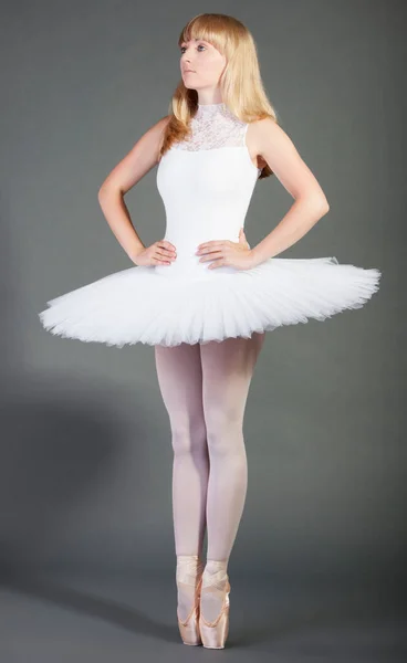 若いです女性バレエダンサーで身に着けていますTutu Tiptoing以上グレーの背景 — ストック写真