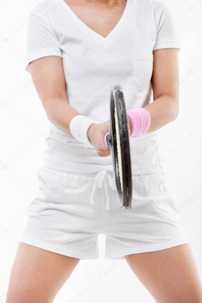 Midsection of young sportswoman holding tennis racket over white background