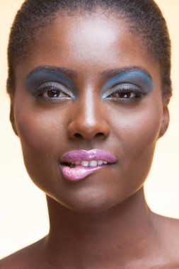 Stüdyoda makyajlı Afro-Amerikan bir kadının portresi.