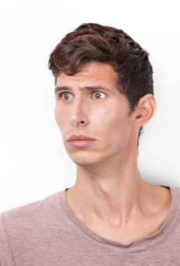 Şok olmuş genç adam beyaz arka plana bakıyor.