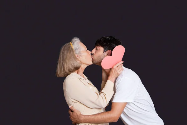 Jongeman Zoenen Senior Vrouw Met Rood Papier Hart Tegen Zwarte — Stockfoto