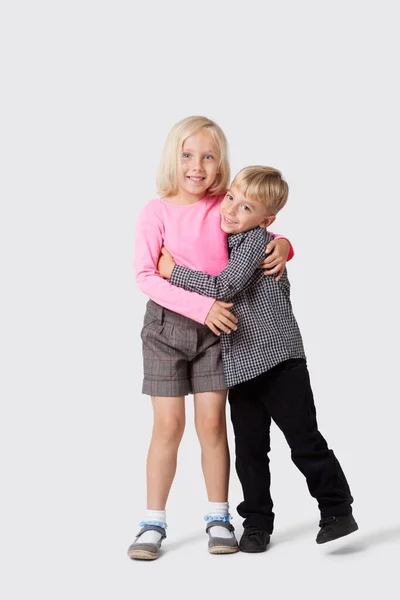 年轻快乐的兄弟姐妹抱着白种人背景的画像 — 图库照片