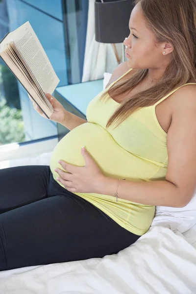 Mladá Těhotná Žena Čtení Knihy Při Relaxaci Posteli Doma — Stock fotografie