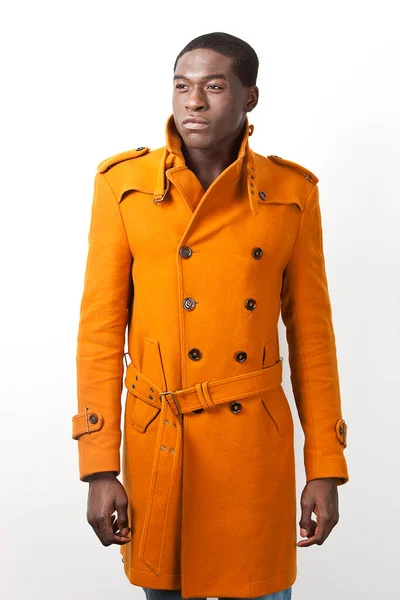 Ung Afroamerikansk Man Orange Trenchcoat Står Mot Vit Bakgrund — Stockfoto