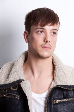 Düşünceli genç adam beyaz arka plana bakıyor.