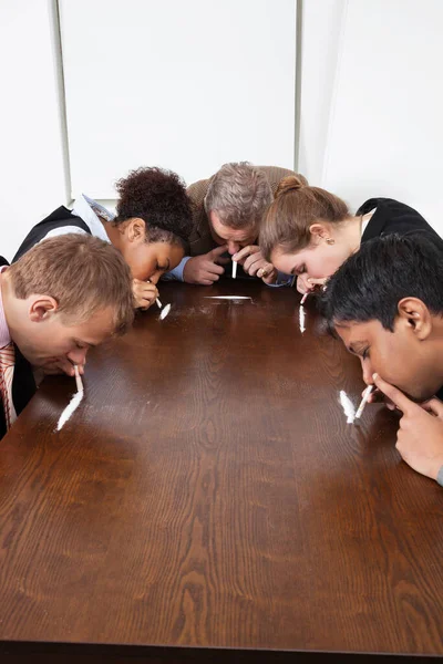 Multietniskt Affärsfolk Som Sniffar Kokain Runt Konferensbordet — Stockfoto