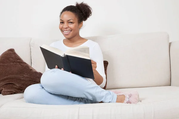 Jovem Mulher Afro Americana Feliz Lendo Livro Sofá — Fotografia de Stock