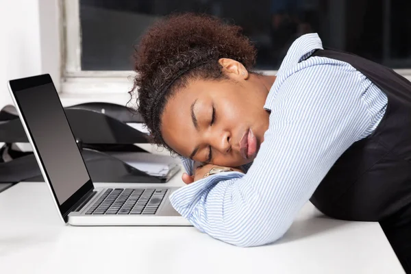 オフィスのノートパソコンに頭を持つ疲れビジネス女性の側面図 — ストック写真