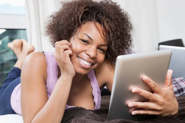 Портрет Счастливой Молодой Афроамериканской Женщины Использующей Планшетный Компьютер Постели — стоковое фото